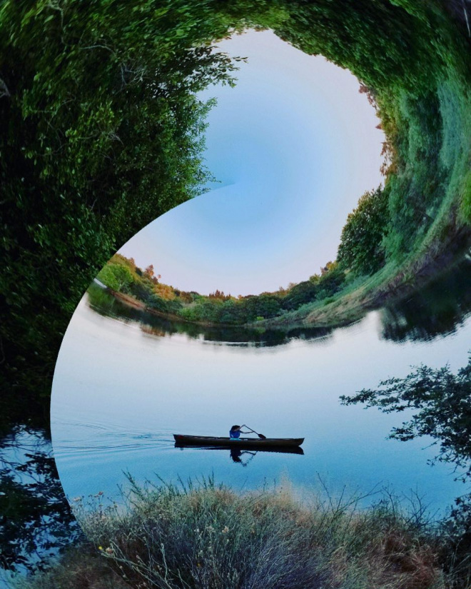 distorted image with river wrapping around person in canoe